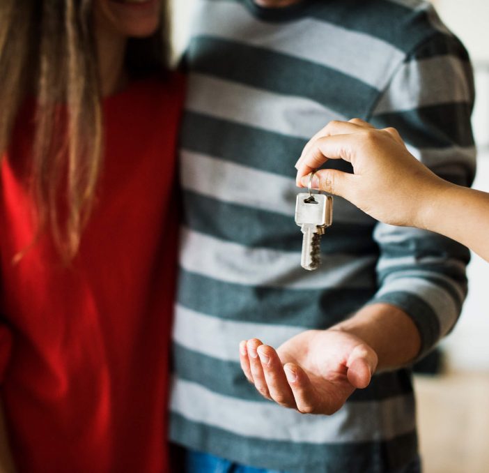 picture of a person handing over keys to a couple