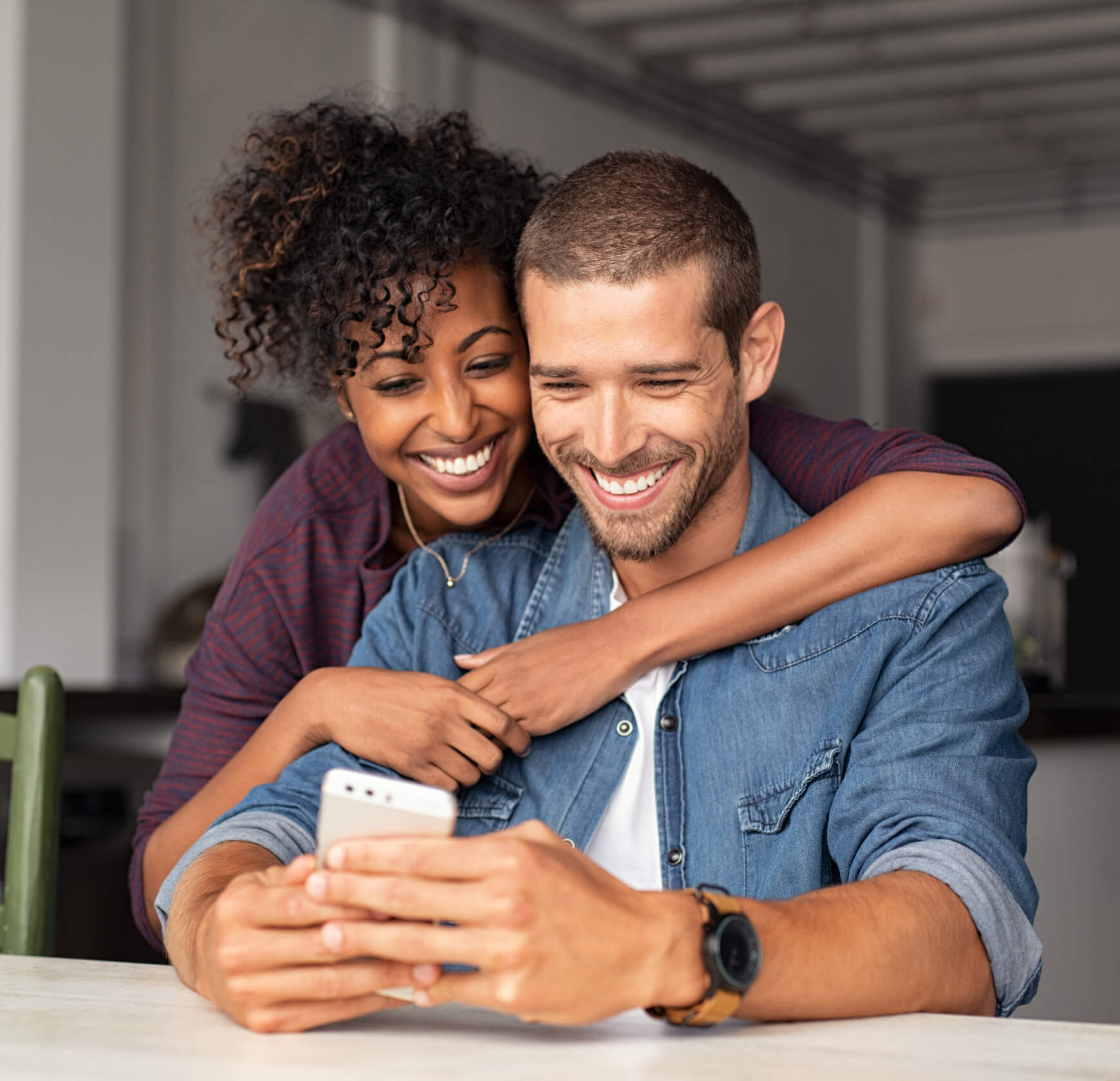 couple smiling while looking at a phone