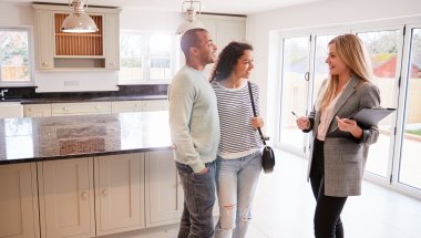 real estate agent standing with couple