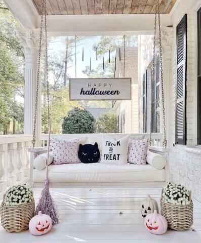 front porch swing with pink pumpkins and mums 
