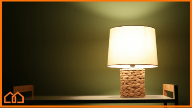 Lamp placed on a high ledge shelf, lighting up a dark room.